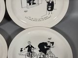 three white plates with black drawings of a man on a bicycle and a woman on a bicycle