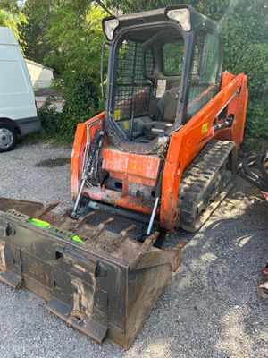 un petit tracteur orange garé sur un parking