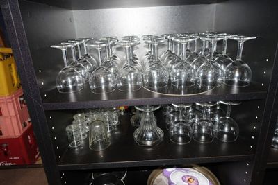 une étagère noire sur laquelle sont posés des verres à vin et des assiettes