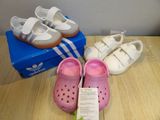 two pairs of baby shoes on a table next to a box