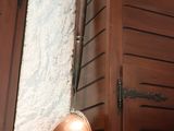 a wall with a pot hanging on it next to a window