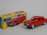 a red toy car next to a yellow box on a white surface