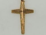 a close up of a gold cross on a white surface