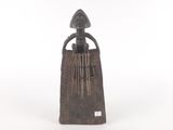 a wooden sculpture of a woman holding a musical instrument