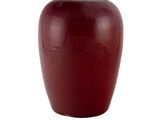 un vase rouge posé sur une surface blanche