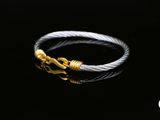 un gros plan d'une bague en argent et en or sur fond noir