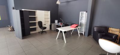 une photo d'une pièce avec un bureau, une chaise et une bibliothèque