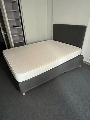 un lit sur lequel est posé un matelas dans une pièce