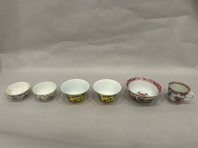 six cups and saucers are lined up on a white surface