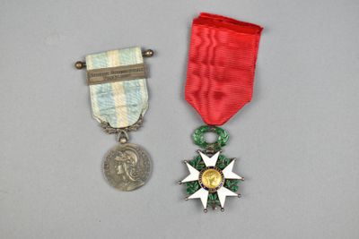 deux médailles et une médaille posée sur une table, à côté d'une pièce de monnaie