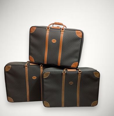 trois bagages empilés les uns sur les autres sur une surface blanche