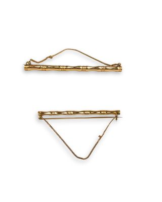 a pair of gold hair clips on a white background