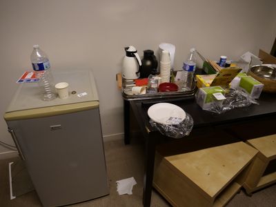 une petite cuisine équipée d'un réfrigérateur et d'une petite table