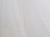 a cat that is sitting on a bed with a white sheet