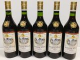 six bottles of wine are lined up on a table