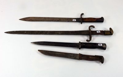 several old knives are lined up on a white surface