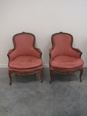 une paire de fauteuils rembourrés roses, placés dans un coin de la pièce