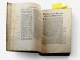 an open book with a yellow post - it on top of it