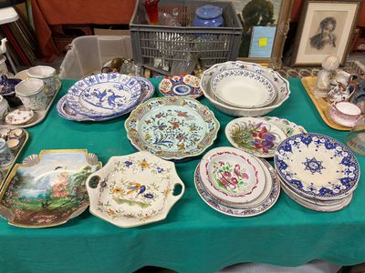 de nombreuses assiettes et bols posés sur une table recouverte d'une nappe verte