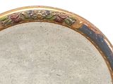 a round mirror with a floral design on it