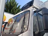 un camion avec des bagages sur le toit, garé sur un parking