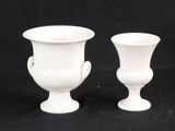 deux vases blancs posés l'un à côté de l'autre sur un fond noir