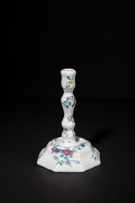 a white candle holder with a floral design on it