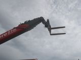 a red crane that is being lifted by a crane