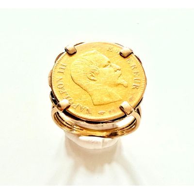 une bague en or surmontée d'une pièce de monnaie