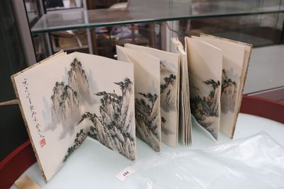 cinq livres exposés sur une table dans une vitrine en verre