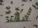 a green and white plate with a lady in a green dress
