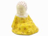 une figurine représentant une femme en robe jaune