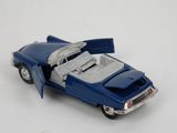 a blue toy car with open doors on a white surface