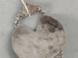 silver plated earrings with a bird on top of them on a white surface