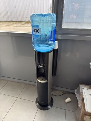 a water dispenser on the floor next to a window