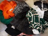 a pile of clothes that is sitting on a bed