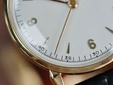 a close up of a gold wrist watch with a white face