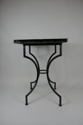 une image représentant une table noire avec un plateau en marbre