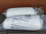deux rouleaux de papier toilette emballés dans du plastique, posés par terre