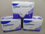 trois boîtes de serviettes hygiéniques empilées les unes sur les autres