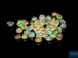 un tas de perles d'oplite blanches sur une surface noire