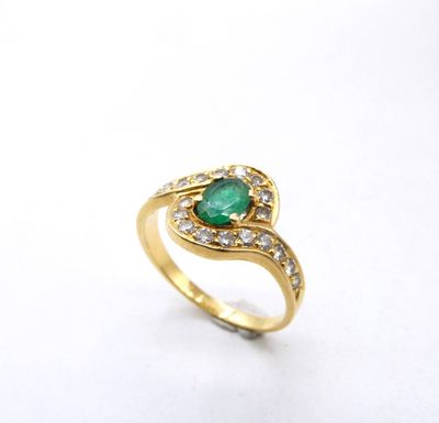 a close up of a gold ring with an emerald stone and diamonds