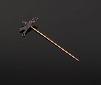 a small metal stick with a bird on it sitting on a black surface