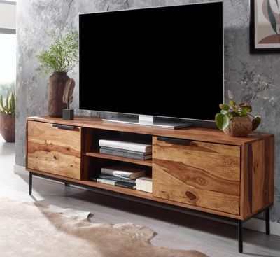 a tv on a stand in a room with a cow skin rug