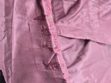 pink satin jacket with a zipper on the back and a small hole in the front