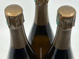 three bottles of wine sitting on top of a white table