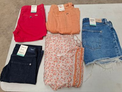 cinq paires de jeans pour femmes posées sur une table