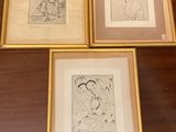 trois dessins encadrés représentant une femme et un homme, posés sur une table