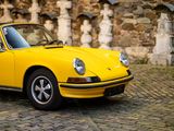 a yellow car parked on a cobblestone street