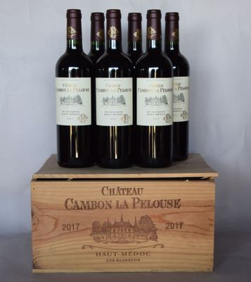 four bottles of wine are in a wooden box on a table